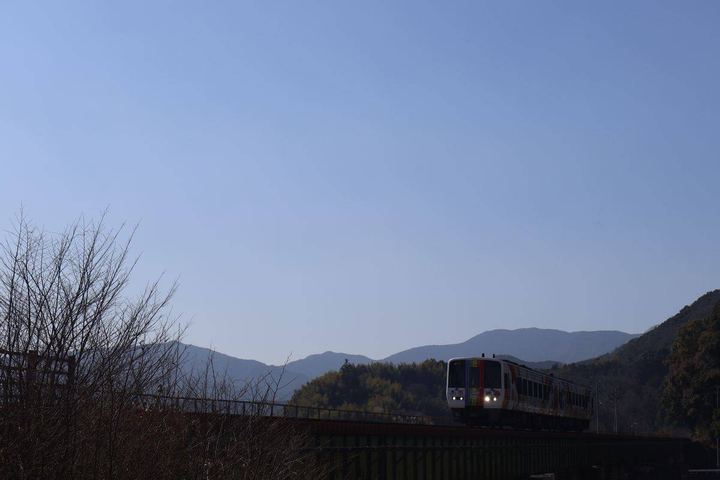 山あいを走る一両編成の普通列車